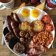 Full English breakfast (19th century) with sausage, bacon, beans and tomatoes (from the Americas, by 18th century) and eggs