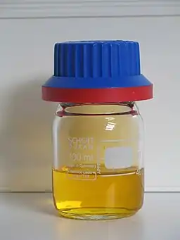 a vail containing some clear golden-brown liquid