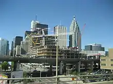 Several skyscraper buildings in background with elevated highway passing in front