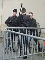 Gendarmes mobiles equipped with shields, FAMAS and gas mask.