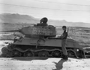 A destroyed tank with writing on it.