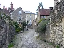 Narrow street between stone walls and houses