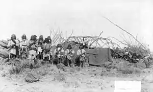 "Scene in Geronimo's camp before surrender to General Crook, March 27, 1886: group in Natches' camp; boys with rifles."