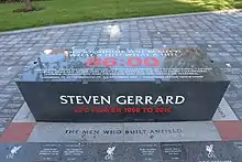 A dark grey plinth with white and red writing on it