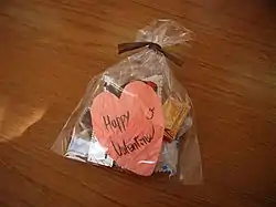 A small plastic bag with chocolates and a heart-shaped note reading "Happy Valentine".