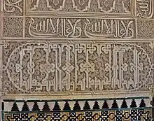 Calligraphy in the Salón de Embajadores in the Alhambra, Granada (14th century): above is the Nasrid motto ("There is no conqueror but God") in cursive script, repeated more than once, while below is a larger inscription in "Knotted" Kufic