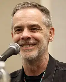 A headshot photo of a white man with a short haircut in T-shirt