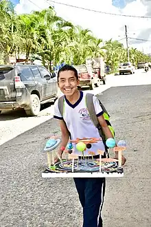 A boy holding a three-dimensional display of the planets in the Solar System