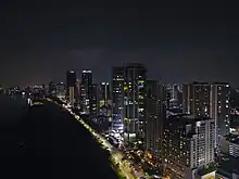 Aerial view of Gurney Drive, lined with skyscrapers, at night