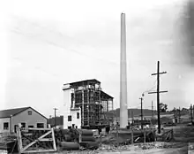 Building site. A chimney has been erected and scaffolding has gone up.