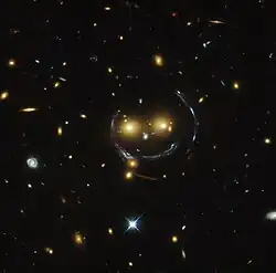 "Smiley" image – galaxy cluster (SDSS J1038+4849) & gravitational lensing (an Einstein ring) (HST).