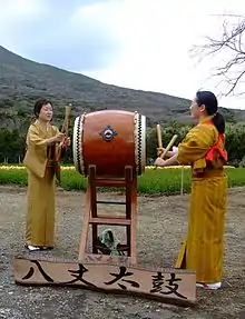 Two women wearing kimonos perform traditional Hachijō-daiko.