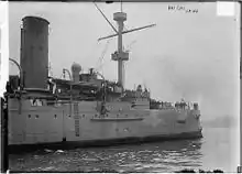 A black-and-white photograph of the bow of a ship entering the picture from the left.  A number of crew members are visible on deck.  The words "HAI CHI CHINA" are visible in the upper right-hand corner of the photo, along with what appears to be the imprint of a stamp.