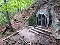 Railway tunnel exit opening out in rough terrain