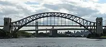 The Hell Gate Bridge's main span in front of the Robert F. Kennedy Bridge's suspension span, as seen from Hell Gate