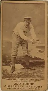 A baseball player is standing, focusing his attention on catching a baseball.