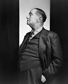 Black and white photograph of H. G. Wells standing and wearing a suit