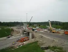 Construction equipment lines a highway overpass