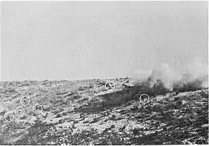 Men on a hill surrounded by explosions