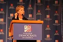 Photograph of Clinton speaking at a lectern to the College Democrats