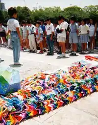 Japanese schoolchildren dedicate a collection of origami cranes for Sadako Sasaki in Hiroshima Peace Park.