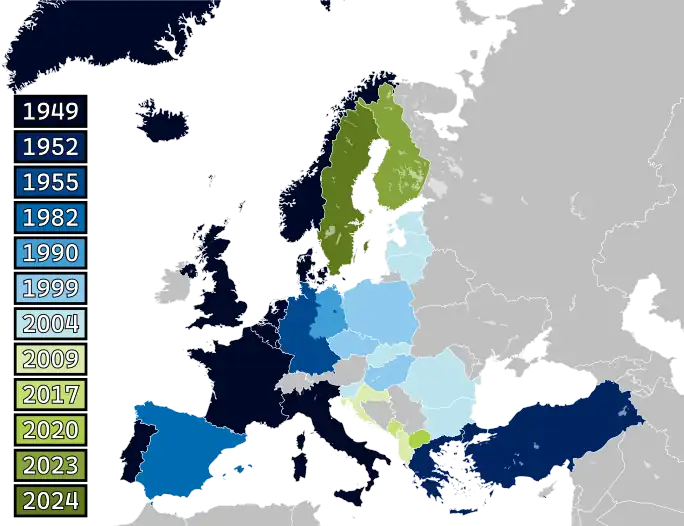 A map of Europe with countries labelled in shades of blue, green, and yellow based on when they joined NATO.