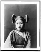 Hopi girl at Walpi, c. 1900, with squash blossom hairstyle indicative of her eligibility for courtship, the squash flower being a symbol of fertility.