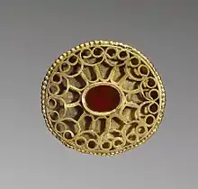 A Hunnish oval openwork fibula set with a carnelian and decorated with a geometric pattern of gold wire, 4th century, Walters Art Museum