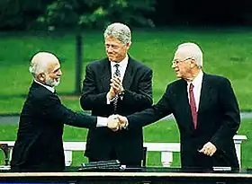 A handshake between King Hussein and PM Rabin, accompanied by President Clinton, during the Israel-Jordan peace negotiations, 25 July 1994