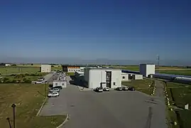 The Virgo site with, in the foreground, the building which hosts the detector control room and the local computer center.