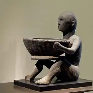 15th century Ifugao bulul with a pamahan (ceremonial bowl) in the Louvre Museum, France.