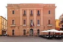 Three-story building, with flags over the entrance