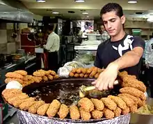  A man in a restaurant kitchen making fritters