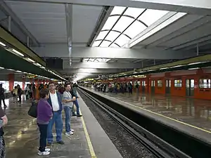 While on one platform passengers are waiting for the arrival of a train, on the other commuters are leaving.