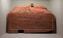 Museum exhibit of a stone slab featuring a Nabataen Aramaic inscription