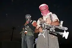 Two masked Iraqi men with weapons during the insurgency that followed the 2003 invasion of Iraq