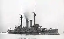 Large warship with smoke rising from the smokestack