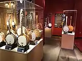 Jazz-Age banjos, American Banjo Museum. In the back is a 1955 Gibson PB-250 banjo, electrified by Les Paul. The instrument is displayed opened up so visitors can see the modifications.