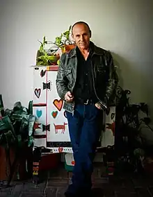 A photograph of a man standing in his studio.