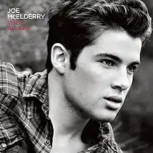 A black-and-white photo of McElderry wearing a plaid shirt. Both the artist's name and album title appear on the top-left corner, colored in white and red respectively.