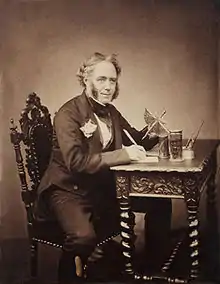 Portrait of Westwood sitting at a writing table