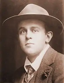 Mid-length photograph of a man of about 25 in a jacket, tie, and fedora.