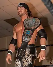 Johnny Impact with the fifth design of the belt, introduced in 2018, in its original blue-painted version