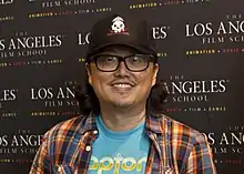  A picture of an Asian man who wears glasses and smilles.