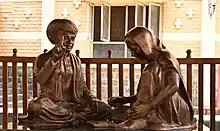 A statue of Jyotirao Phule teaching Savitribai Phule, at Pune.