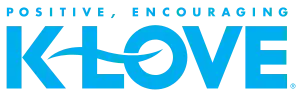 The K-Love network logo: the letters K and LOVE, with a stylized swoosh forming the dash and crossing the L and O, with the words "Positive, Encouraging" on top, all in light blue.