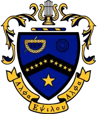 Coat of Arms of Kappa Kappa Psi. A blue shield is divided by a black chevron, on which ten gold stars are placed: five on the left side of the chevron, five on the right. On the upper-left side is a representation of the fraternity badge in gold and black. On the upper right are three black circles. In the lower half of the shield, there is a large gold star. The shield is capped by a bar of alternating blue and gold, over which rests a golden lyre. Decorative mantling of gold with blue surrounds the crest. Beneath the crest is a golden scroll, on which are written the Greek words "Alpha Epsilon Alpha."