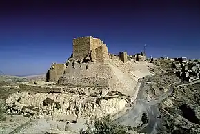 A castle built of stones on a cliff near a settlement