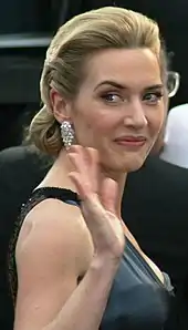 Kate Winslet smiles and waves at the camera.