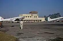 Two planes on the tarmac in front of an airport building